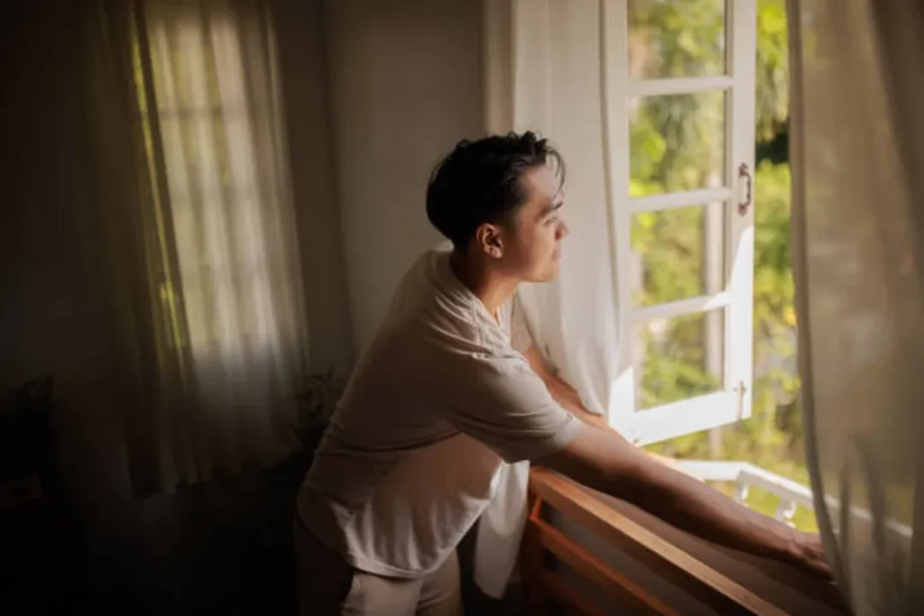 man cleaning floor opening window