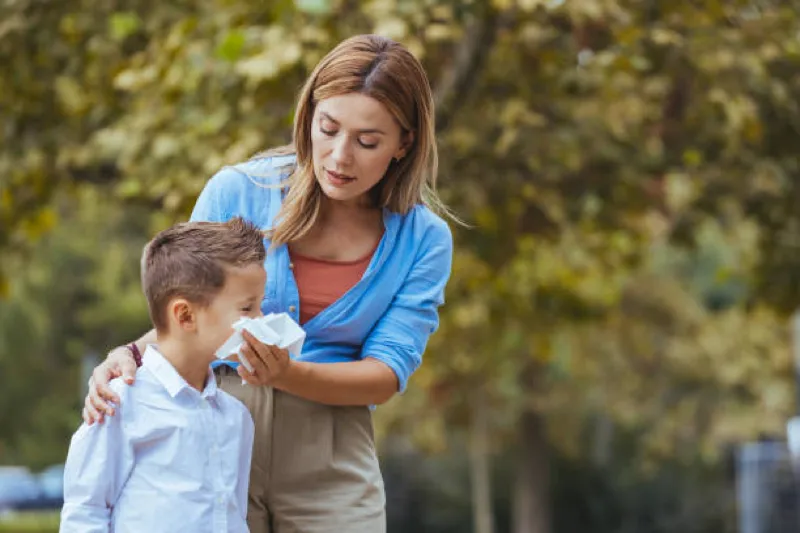 parent blowing sick childs nose
