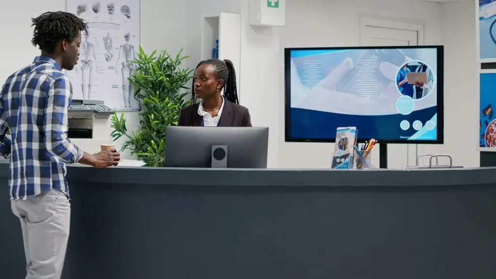 man woman talking at office reception desk