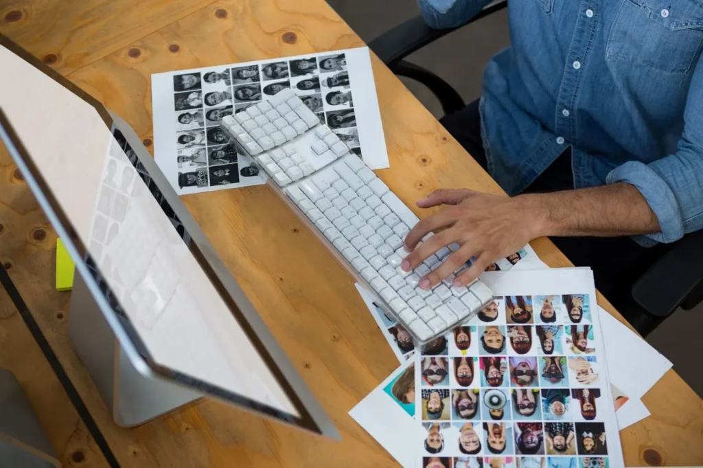 office worker looking photos computer keyboard